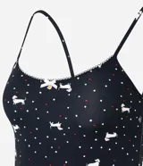 Musculosa de pijama confeccionada en microfibra color negro con estampa de lunares y perritos blancos. Tiene breteles finos fijos y picueta en el escote.