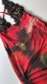 Minivestido con estampado floral en tonos rojos y negros, con escote halter de encaje negro.