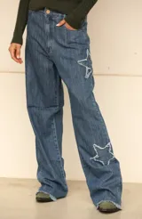Pantalón de jean gris con estrellas de denim más oscuro y terminaciones desflecadas.