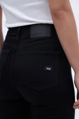 Pantalón de jean negro de tiro medio con calce ajustado desde la cintura hasta los tobillos.
