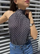 Top negro con lunares blancos, cuello halter y espalda descubierta.