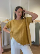 Blusa de lino color mostaza, de manga corta y corte amplio con frunce bajo el busto.