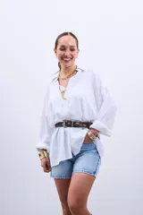 Camisa blanca oversize de manga larga con cuello clásico y cierre frontal con botones.