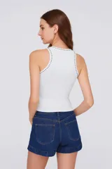 Musculosa negra de algodón y elastano, corte ajustado, con cuello redondo y tachas plateadas en cuello y sisas.