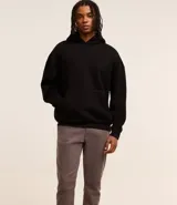 Pantalón de vestir marrón, de corte skinny, con bolsillos laterales y traseros. Se ajusta a la cintura con cinturón de cuero marrón.