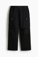 Pantalón cargo negro de corte holgado, con cintura elástica, bolsillos laterales, bolsillos tipo cargo con solapa y botón a presión en los laterales y bolsillos traseros con solapa y botón a presión.