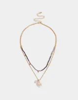 Collar corto multicadena con mostacillas lilas y dije de corazón místico dorado.