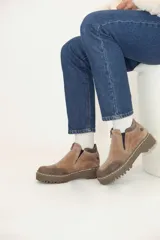 Bota marrón de cuero con plataforma y cierre frontal con cremallera.