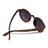 Lentes de sol con montura redonda de madera y lentes degradadas de gris a transparente.