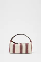 Bolso de mano tipo city, confeccionado en tejido con estampado de rayas verticales en tonos crudo y bordó. Tiene doble correa de hombro extraíble en contraste de tejidos, detalles metálicos y cierre mediante cremallera.