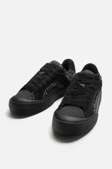 Zapatillas de skate negras con detalles en denim y cuero serraje.