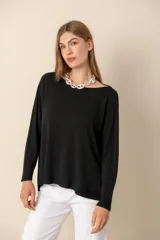 Sweater verde claro liso de manga larga con cuello bote y aberturas laterales.