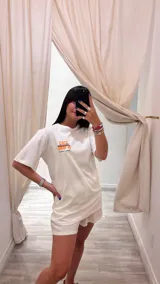Remerón blanco con estampado colorido en el pecho, de corte holgado y manga corta.