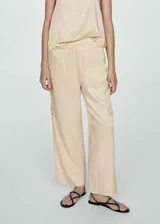 Pantalón color beige de corte recto y largo, con cintura elástica, bolsillos laterales y traseros, y bolsillos cargo en los laterales.