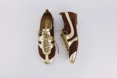 Zapato tipo ballerina acordonado, color marrón con detalles en plateado. Fabricado en cuero.