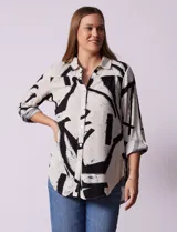 Camisa de manga larga con estampado abstracto en blanco y negro, cuello con solapa y abertura central con botones.