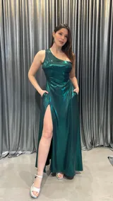 Vestido largo de fiesta color verde esmeralda brillante, de un solo hombro, con abertura en la pierna izquierda.