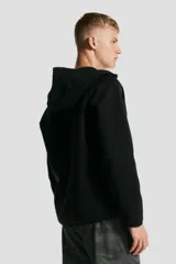 Campera deportiva negra con capucha, cierre frontal, bolsillos con cierre y mangas raglán. Confeccionada en tejido funcional efecto neopreno DryMove™ que ayuda a absorber el sudor.