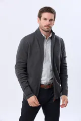 Campera tejida de lana color azul marino, con cuello alto, cierre metálico frontal y bolsillos laterales. Presenta detalles en cuero y logo bordado.