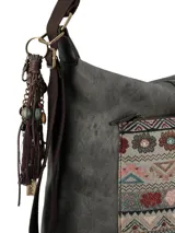 Cartera hobo convertible en mochila, color gris, con un bolsillo frontal de diseño patchwork floral y geométrico. Incluye un llavero con dijes y borlas. Tiene cierre cremallera en el compartimento principal, bolsillo delantero con cierre y broche magnético, bolsillo trasero con cierre y bolsillo interior con cierre. La correa es ajustable y desmontable.