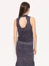 Top verde de tejido de punto con hilo metálico, corte ajustado y cuello alto.