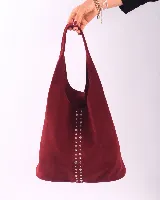 Bolso de hombro color borgoña, hecho de cuero gamuzado, con tachas plateadas verticales.