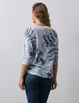 Buzo blanco con estampado de hojas en tonos azulados, de cuello redondo y mangas 3/4.