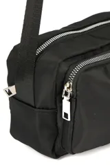 Bandolera color beige con correa larga negra ajustable. Tiene dos compartimentos con cierre y un bolsillo frontal con cierre.
