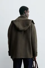 Parka verde oscuro confeccionada en tejido con lana, corte regular, cuello solapa con capucha desmontable, manga larga con puño ajustable, bolsillos de vivo en cadera y cierre frontal con cremallera oculta por solapa con botones a presión.