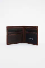 Billetera de cuero color marrón con corte, cambio de cuero y pespuntes decorativos. Interior con reparticiones y forro de algodón en los bolsillos.