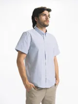 Camisa de hombre de manga corta con estampado a cuadros en tonos blanco, verde y marrón. Tiene cuello abotonado y bolsillo en el pecho.