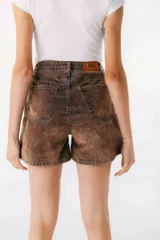 Short de jean color marrón con efecto desgastado, tiro alto y corte holgado.