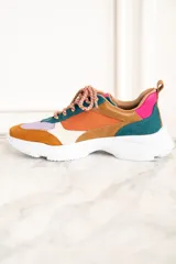 Zapatillas deportivas con paneles de cuero, gamuza y malla en colores naranja, marrón, verde, lila y crema. Cordones gruesos multicolor y suela chunky blanca.