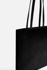 Bolso tipo shopper fabricado en cuero color negro. Tiene un bolsillo interior plano con cierre mediante cremallera y asas de cuero.