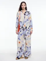 Camisa de manga larga confeccionada en viscosa crinkled con estampa de manchas. De silueta amplia y fluida, con bolsillos frontales grandes, tajos laterales y largo extendido en la espalda.