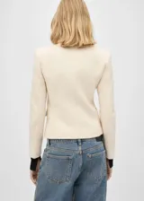 Blazer color crudo confeccionado en tejido tweed con mezcla de algodón y lana. Presenta cuello de pico con solapa, dos bolsillos de parche en el pecho, solapas con muesca, diseño recto, dos bolsillos de solapa en la parte delantera, cierre delantero con botones, diseño entallado y forro interior.