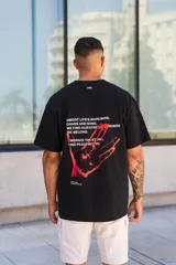 Remera negra de algodón con estampado en la espalda que incluye una mano roja y texto en blanco.