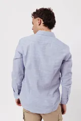 Camisa celeste de manga larga con cuello clásico y corte slim.