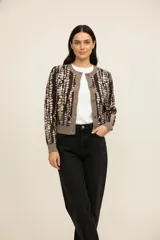 Cardigan de poliéster, recto, con cuello redondo y botones frontales. Presenta un estampado abstracto en tonos marrón oscuro, beige y gris claro. Los puños, el ruedo y el borde frontal son de color gris liso.