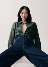 Camisa verde militar de lino y algodón, con cuello camisero, cierre frontal con botones, manga larga con puños abotonados y bolsillo de parche en el pecho.