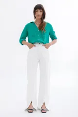 Pantalón jean blanco de corte wide leg con aberturas en el ruedo.