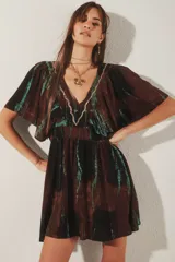 Vestido corto marrón con estampado tie-dye en tonos turquesa y negro, escote en V con bordado de lurex, mangas cortas amplias y cintura elastizada.