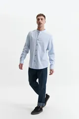 Camisa azul de manga larga con cuello mao y cartera abotonada.