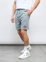 Bermuda gris de felpa sin friza, con cintura elástica ajustable con cordón y logo Umbro estampado en rojo en la pierna izquierda.
