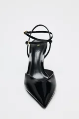 Zapato de tacón destalonado negro acharolado con tiras finas cruzadas ajustables con hebilla al tobillo y punta fina.