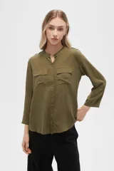 Camisa de viscosa con estampado floral en tonos azul, beige y blanco. Tiene cuello mao, mangas largas y bolsillos en el pecho.