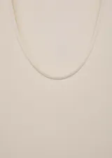 Vestido midi color crema, con tirantes anchos y escote redondo. Presenta panel fruncido en la cintura y falda evasé.