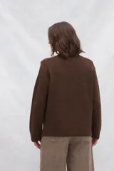 Cárdigan marrón de tejido de punto industrial con escote en V, combinación de puntos y botones en las mangas.