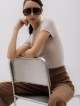 Top de punto color beige, con cuello redondo y mangas cortas.