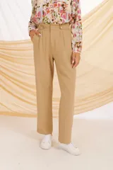 Pantalón negro de corte alto, con botones decorativos en la parte frontal y bolsillos laterales.